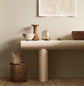Minimalist console table with decor and baskets against a golden beige wall painted with Jotun's colour 12308 Unbleached.