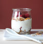 En rik rød vegg, malt i fargen 2859 Whispering Red fra Jotun, gir varme og dybde til en enkel frokost med yoghurt, granola og bær.
